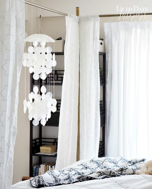 A capize shell hanging on a gold canopy bed makes for easy summer decorating. 