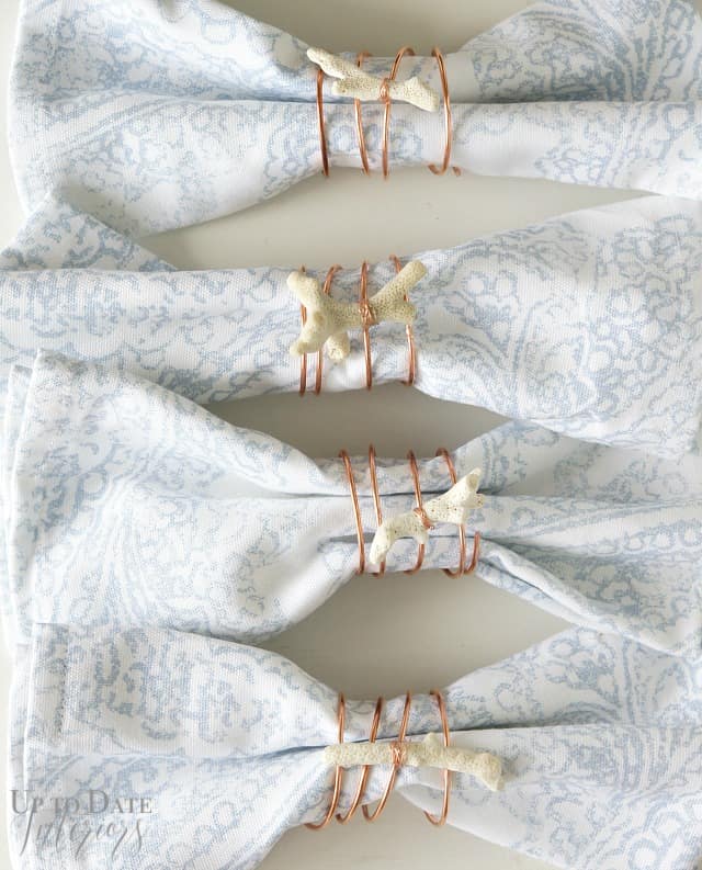 DIY summer decor showing copper and coral napkin rings with blue and white cloth napkins.