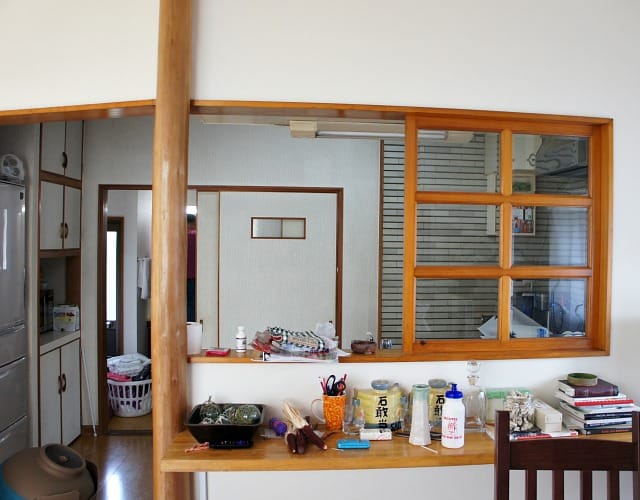 A rental kitchen in traditional Japanese home with a pass through, wood French window, and wood bar. 