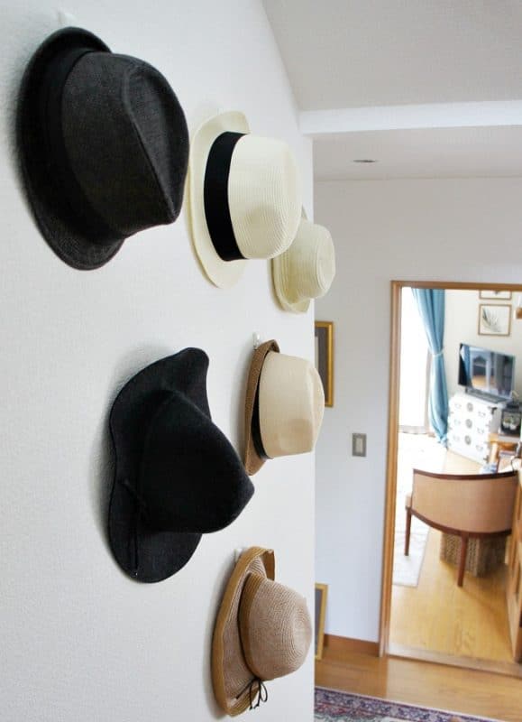 Eclectic summer home tour with a hat wall display in the foyer.