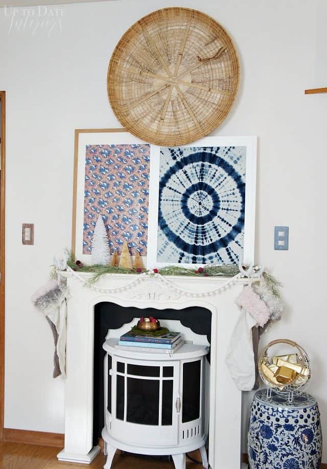 A boho Christmas mantel in eclectic global style with easy decorating ideas including a white Christmas mantel surround around a white eclectric stove with Chinoiserie garden seat and art. 