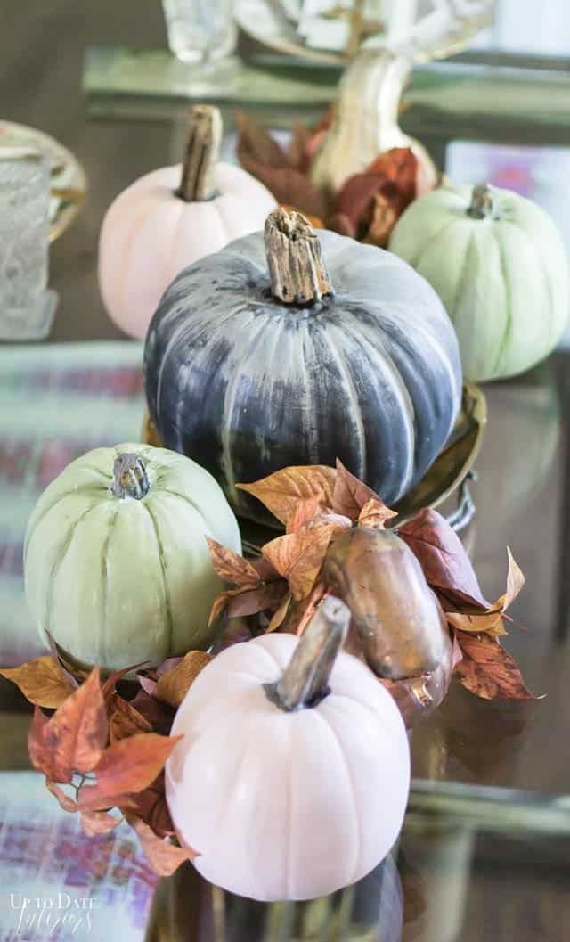 Black, pink, and mint green heirloom faux pumpkins with real stems mixed with gilded gourds and fall leaves for easy decorating Thanksgiving table on a budget. 