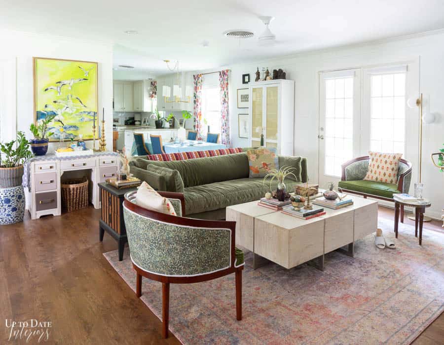 How much to spend on a sofa depends on where you shop.  THe green velvet sofa in this living room came from Facebook marketplace and looks gorgeous in a colorful and eclectic open layout. 