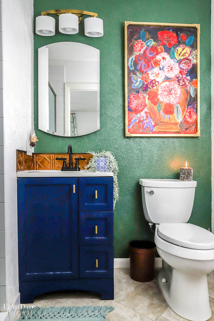 A small ensuite bathroom featuring jewel colors and bold art. 
