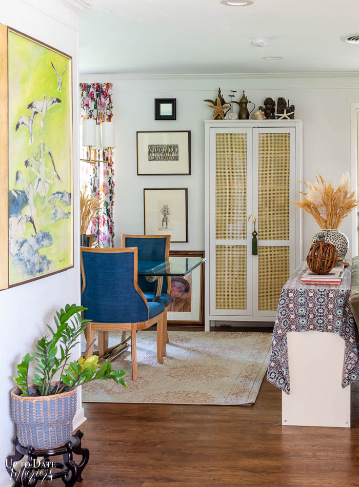 White walls with a DIY cane cabinet set a neutral backdrop for nuetral fall decor with blue accents. 