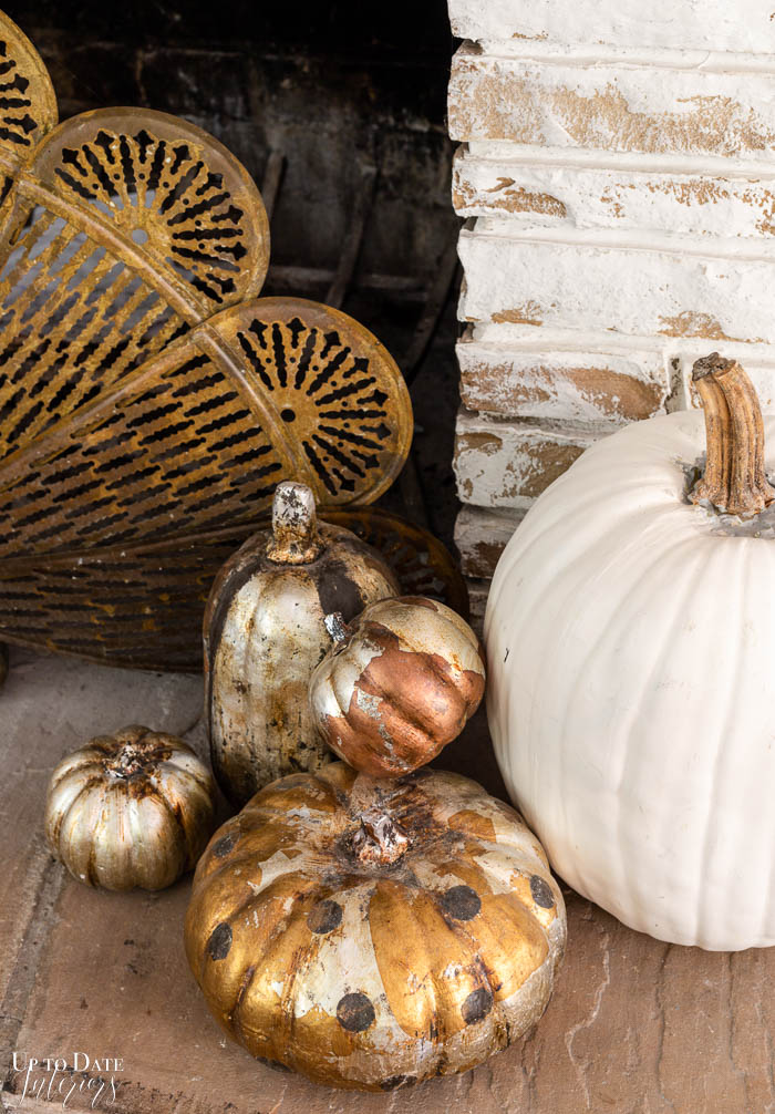 DIY gilded glam pumpkins on fireplace hearth. 