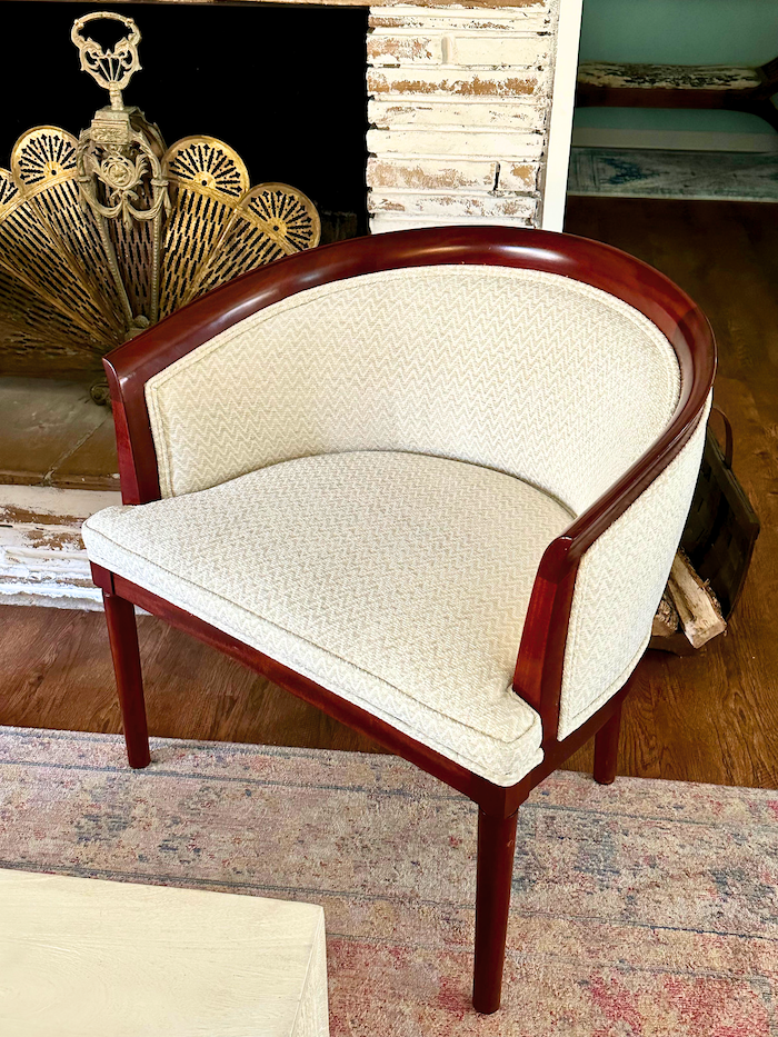 A professhionaly reuphosltered wood barrel chair in a cream fabric. 